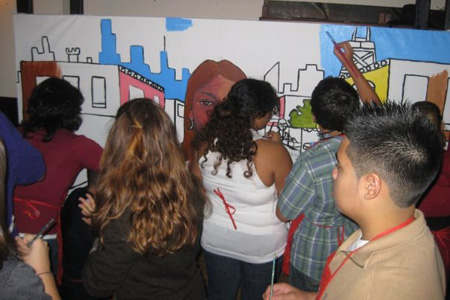 Teens help muralist Gamaliel Ramirez complete the Mango Street mural.